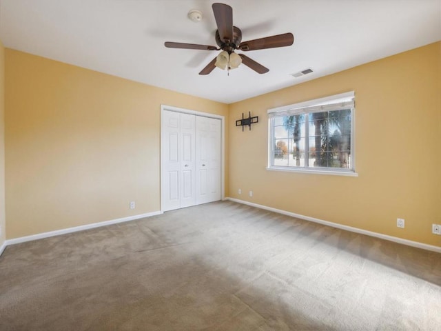 unfurnished bedroom with carpet, a closet, and ceiling fan