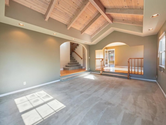 unfurnished living room with carpet, wood ceiling, and vaulted ceiling with beams