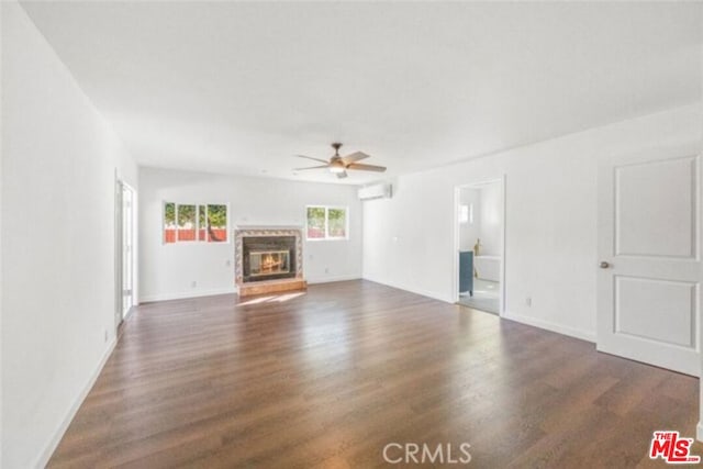 unfurnished living room with ceiling fan, dark hardwood / wood-style flooring, and an AC wall unit