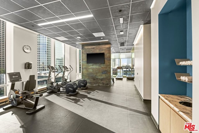 gym featuring a drop ceiling and expansive windows