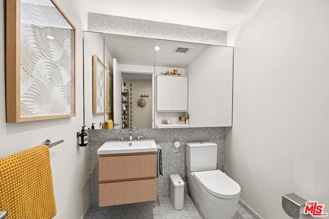 bathroom featuring toilet, decorative backsplash, and vanity