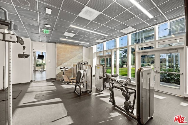 workout area featuring a paneled ceiling and plenty of natural light