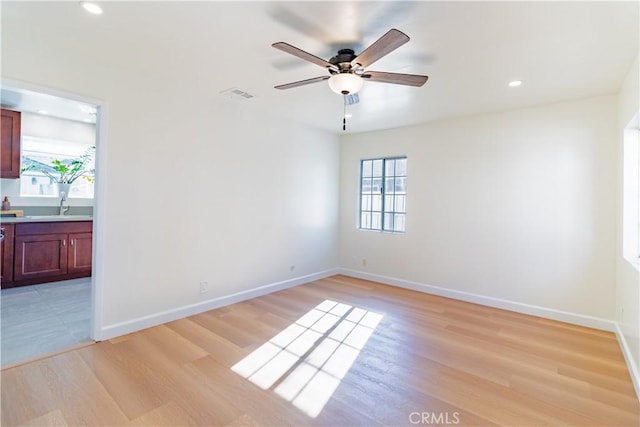 empty room with ceiling fan, light hardwood / wood-style floors, and sink