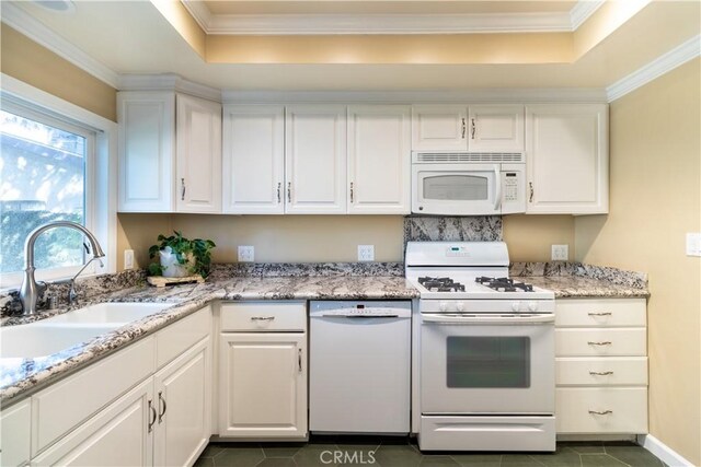 kitchen featuring white appliances, white cabinetry, and sink