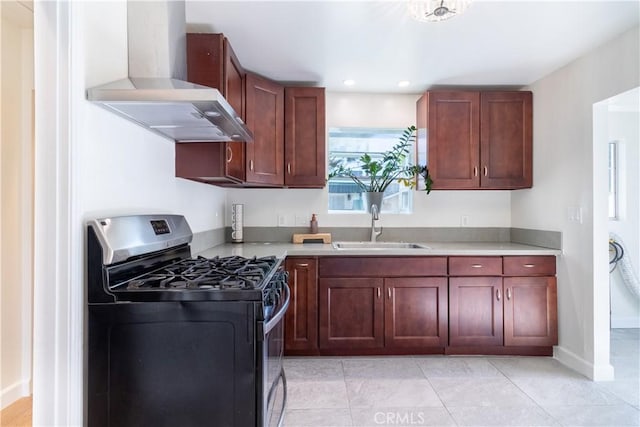 kitchen featuring gas stove, sink, wall chimney exhaust hood, and light tile patterned flooring