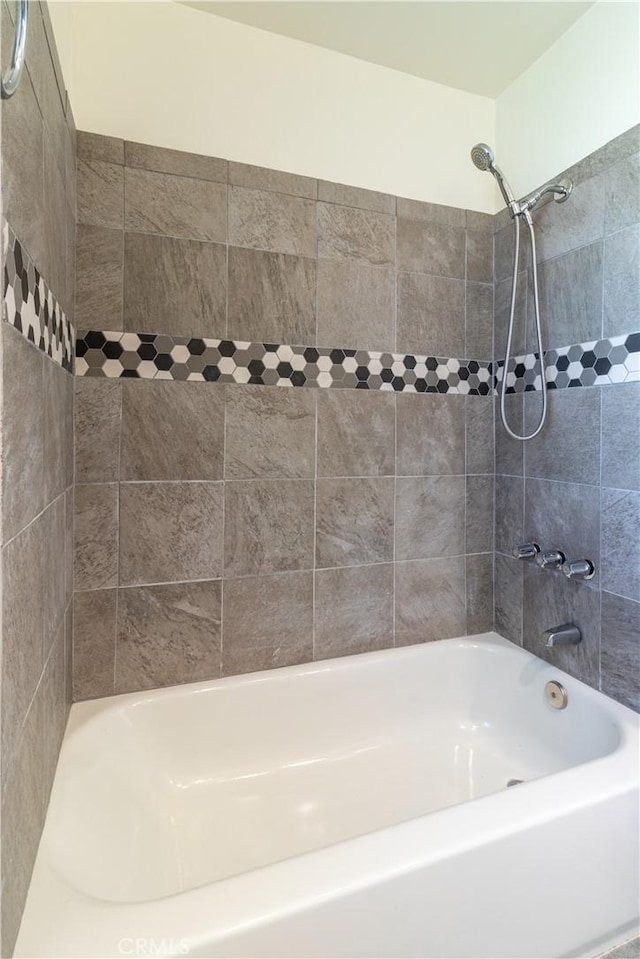 bathroom featuring tiled shower / bath