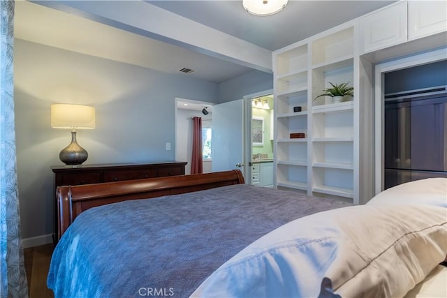 bedroom with ensuite bathroom and a closet