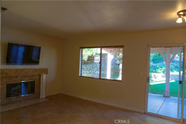 unfurnished living room with light tile patterned floors and a tile fireplace