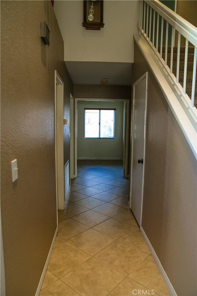 hall with light tile patterned floors