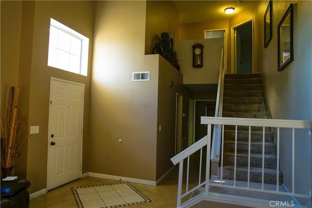 tiled foyer entrance with a high ceiling