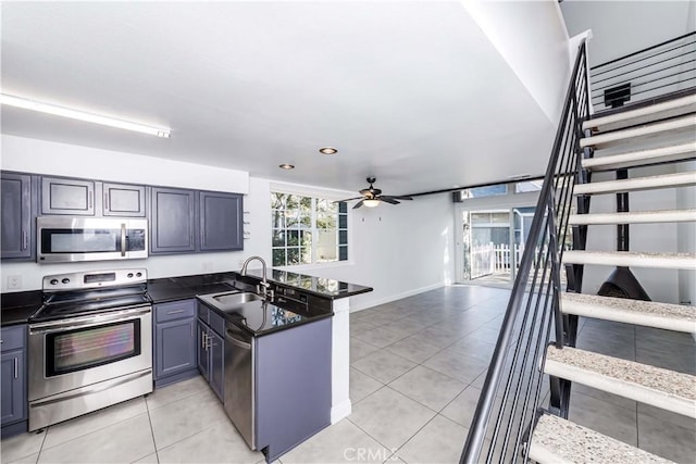 kitchen featuring kitchen peninsula, ceiling fan, stainless steel appliances, light tile patterned flooring, and sink