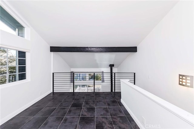 hall featuring vaulted ceiling with beams and dark tile patterned flooring