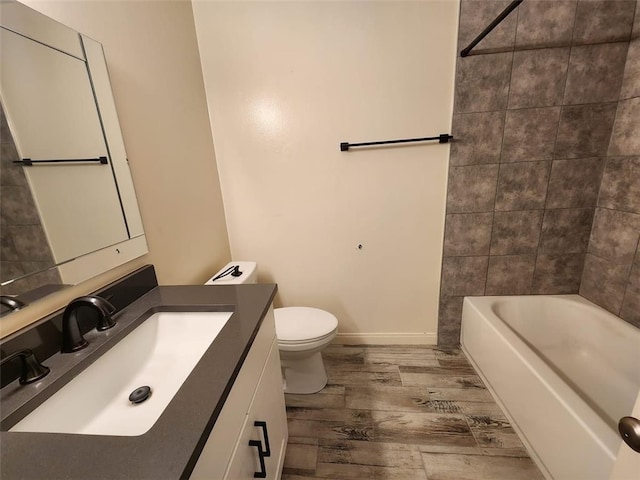 full bathroom with hardwood / wood-style flooring, washtub / shower combination, toilet, and vanity