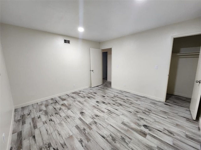 unfurnished bedroom featuring a closet and light wood-type flooring