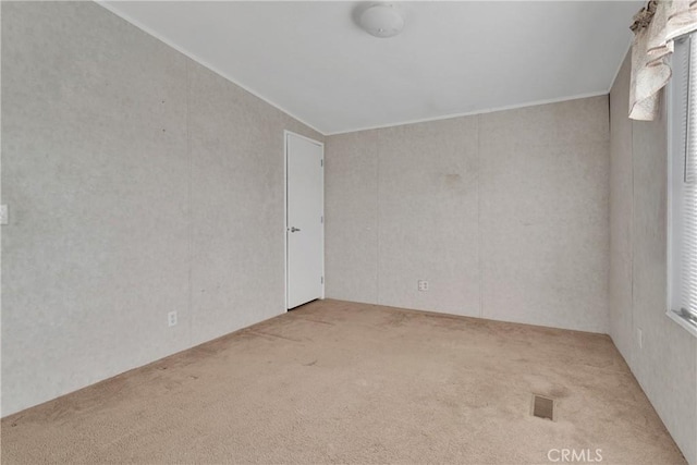 spare room with light colored carpet and vaulted ceiling