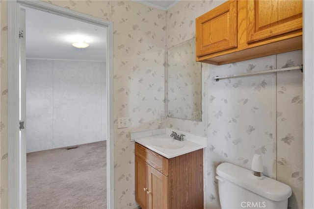 bathroom with vanity, toilet, and ornamental molding