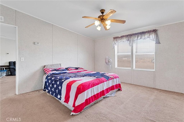 carpeted bedroom featuring ceiling fan and ornamental molding