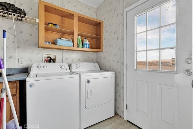 clothes washing area featuring washing machine and clothes dryer and light wood-type flooring