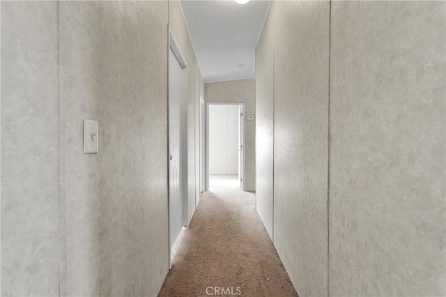 corridor with light colored carpet and vaulted ceiling