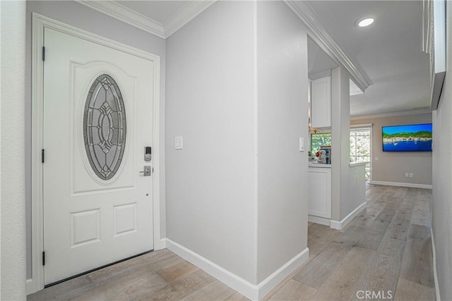 foyer with crown molding and light hardwood / wood-style flooring