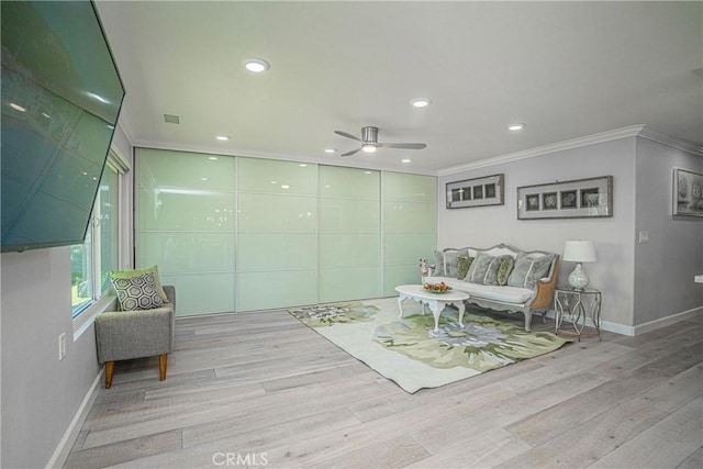 living area featuring ceiling fan, light hardwood / wood-style floors, and ornamental molding