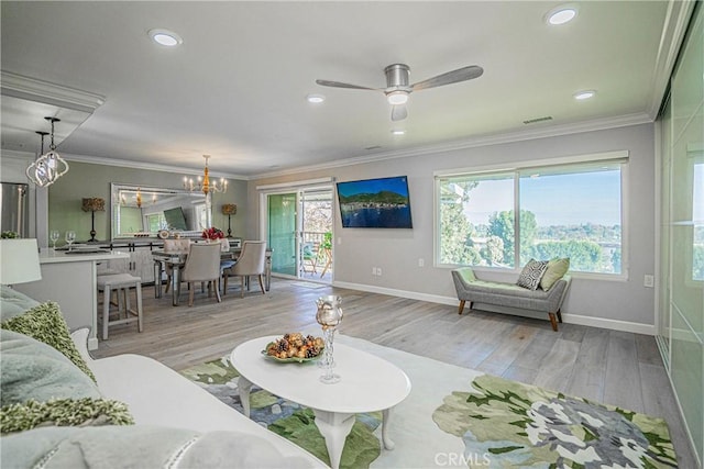 living room with crown molding, ceiling fan with notable chandelier, and light hardwood / wood-style floors