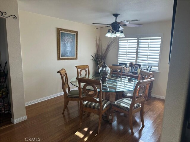 dining room with ceiling fan and dark wood-type flooring