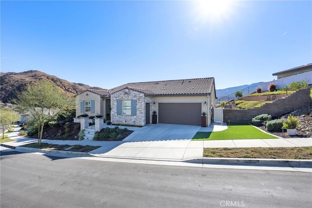 view of front of home featuring a mountain view, a garage, and a front yard