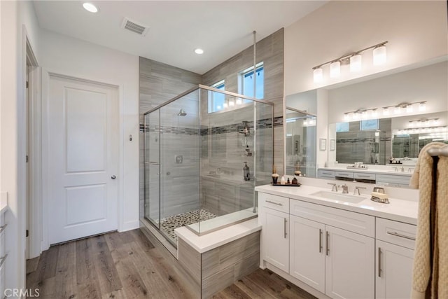 bathroom with hardwood / wood-style floors, vanity, and walk in shower