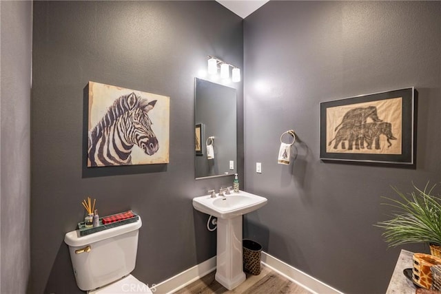 bathroom with toilet and hardwood / wood-style flooring