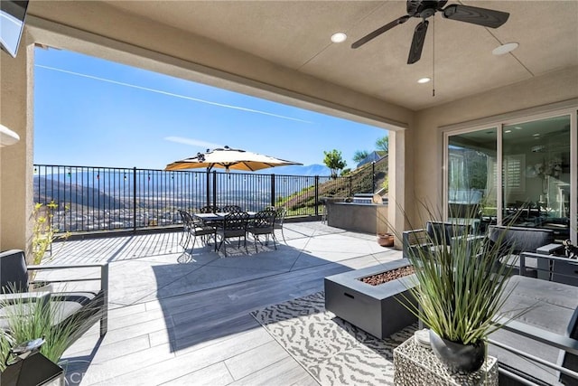 view of patio / terrace with a fire pit and ceiling fan