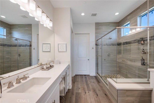 bathroom with a shower with door, vanity, and hardwood / wood-style flooring