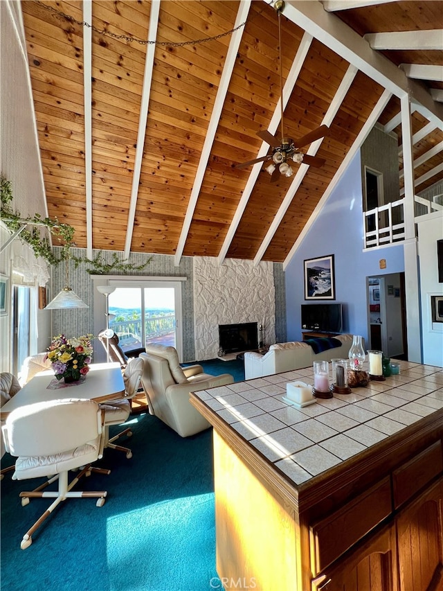 carpeted living room featuring high vaulted ceiling, beam ceiling, wood ceiling, and a fireplace