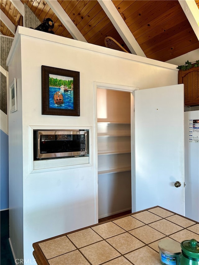 kitchen featuring high vaulted ceiling, beamed ceiling, tile counters, and wood ceiling