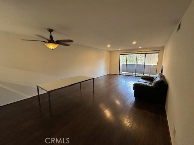 unfurnished living room with ceiling fan and dark hardwood / wood-style flooring