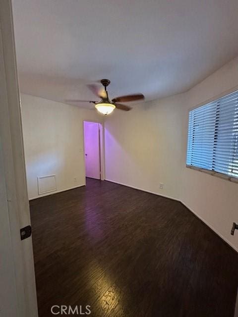 empty room featuring ceiling fan and dark wood-type flooring