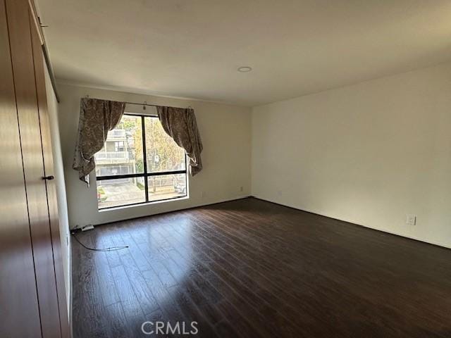 empty room with dark hardwood / wood-style flooring