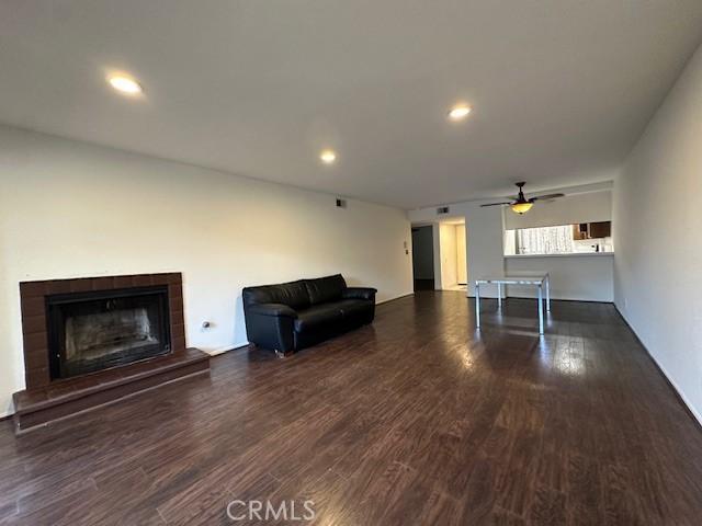 unfurnished living room featuring dark hardwood / wood-style flooring and a tile fireplace