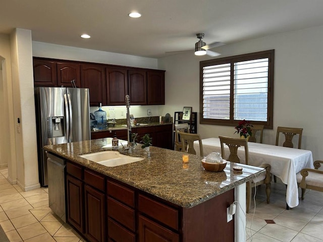 kitchen featuring ceiling fan, stone counters, sink, a kitchen island with sink, and stainless steel appliances