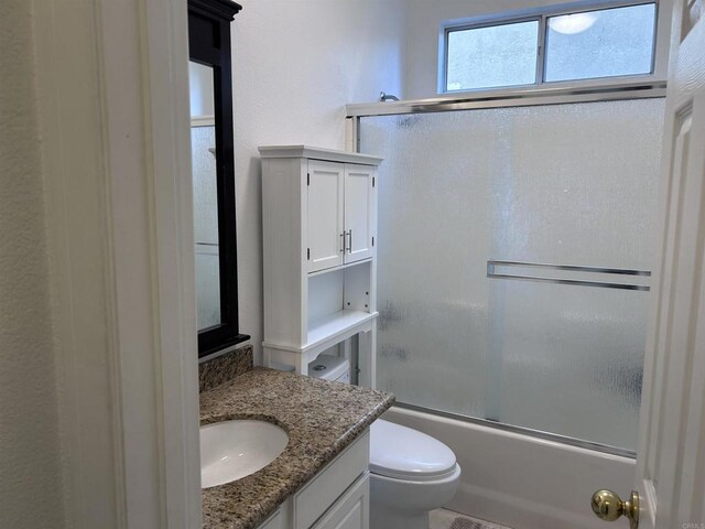 full bathroom with shower / bath combination with glass door, vanity, and toilet