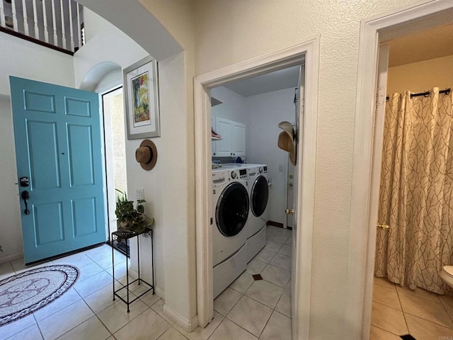 clothes washing area featuring light tile patterned floors and washer and clothes dryer