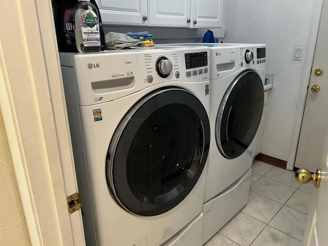 clothes washing area with cabinets, separate washer and dryer, and light tile patterned flooring