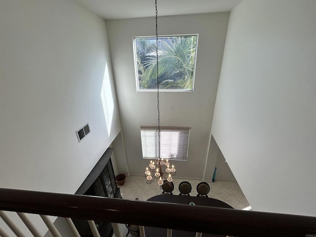 staircase with an inviting chandelier and a towering ceiling