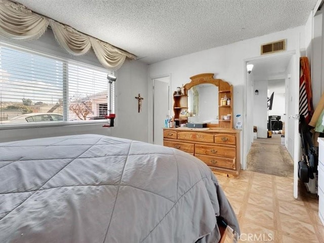 bedroom featuring light parquet flooring and a textured ceiling