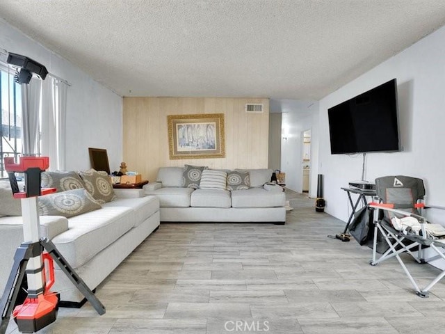 living room with wood walls and a textured ceiling