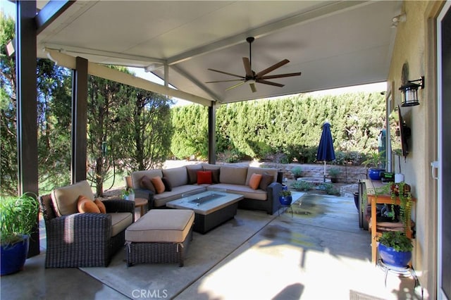 view of patio with ceiling fan and an outdoor living space with a fire pit