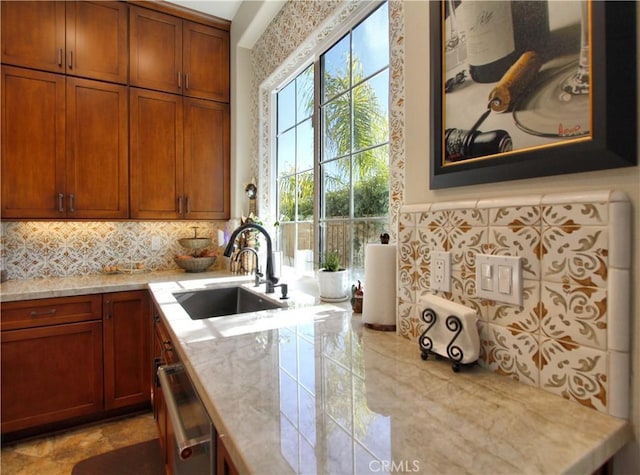 kitchen featuring stainless steel dishwasher, sink, and tasteful backsplash