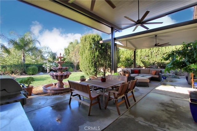 view of patio / terrace with area for grilling, ceiling fan, and a fire pit