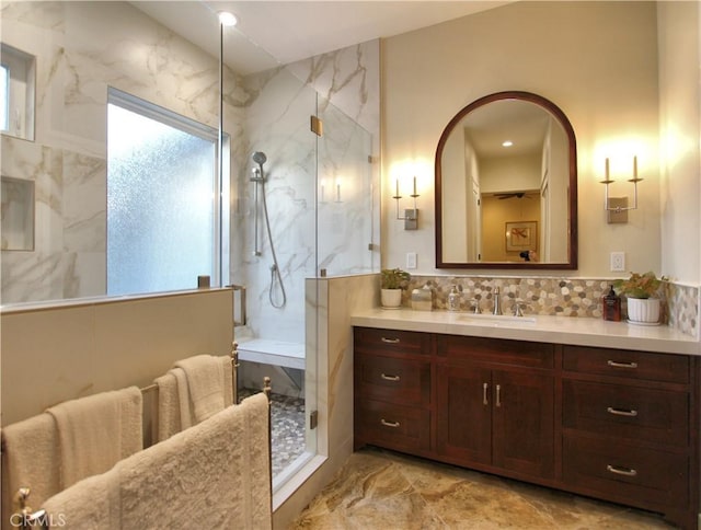 bathroom with backsplash, a shower with door, and vanity