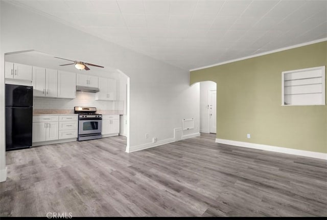 kitchen with black fridge, light hardwood / wood-style flooring, stainless steel range oven, crown molding, and white cabinets